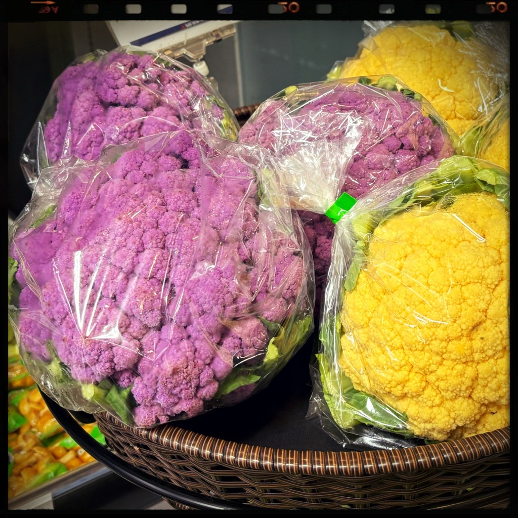 A basket of purple cauliflower and yellow cauliflower.