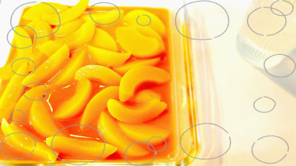 A square glass pan is filled with sliced yellow-orange peaches in a cinnamon brown filling.